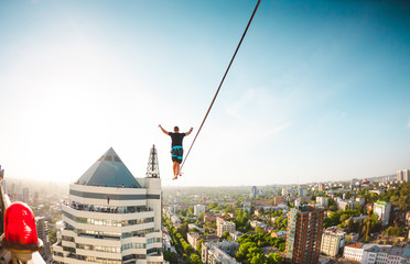 The man is balancing over the city.