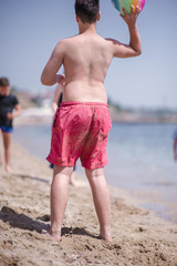 Young kid playing with ball on the beach