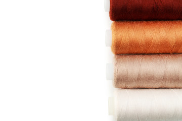 Colourful thread spools on white background