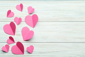 Pink paper hearts on white wooden table