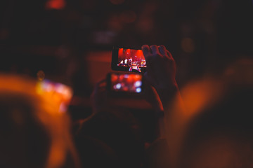 A crowded concert hall with scene stage lights, rock show performance, with people silhouette and...