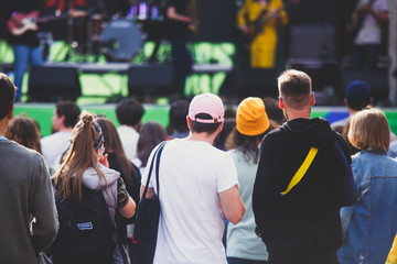 A crowded concert hall with scene stage lights, rock show performance, with people silhouette and...