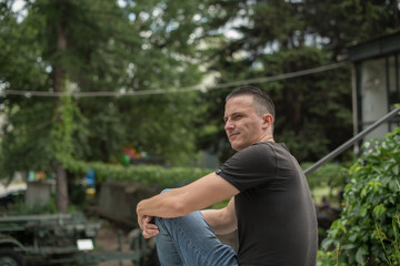 young man sitting in park and enjoying in sunny day 