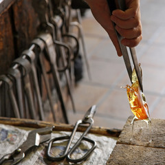 Glass Artist in her workshop making glassware