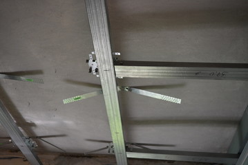 Building materials for a suspended ceiling from a directing and ceiling profile installed on the wall