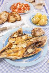 Grilled european seabass with potato and tomato salad