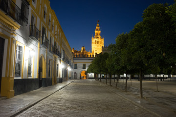 Fototapeta na wymiar Spain, Seville, ILLUMINATED BUILDINGS IN CITY AGAINST CLEAR SKY
