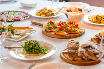 croutons with bacon and vegetables on a wooden tray on a banquet table