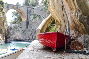 Fiordo di Furore beach. Furore Fjord Amalfi Coast Positano Naples Italy. - Fishermen colored boats on the beach, under the bridge of the fjord. The turquoise water of the beach. - obrazy, fototapety, plakaty