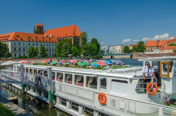 Touristic cruise ship waiting for passengers on the river in Wroclaw, Poland. Colorful recreation zone with chairs on the top of the ship.
