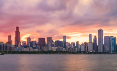 Fototapeta premium Chicago skyline at sunset with cloudy sky and reflection in water.