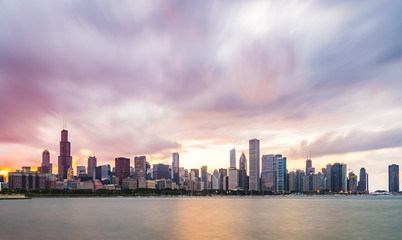 Fototapeta na wymiar chicago,illinois,usa. 8-11-17: Chicago skyline at sunset with cloudy sky and reflection in water.
