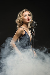Sexy girl singer singing with silver retro microphone