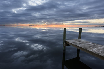 Dock at Dawn with Clouds Reflecting in Water
