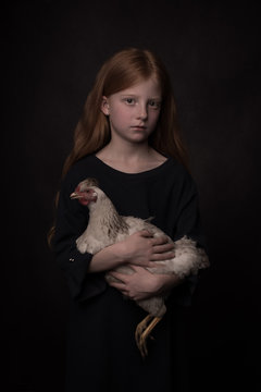 Classic studio portrait of girl with chicken