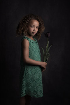 Studio portrait of girl holding flower