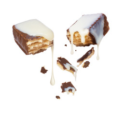 Waffle chocolate bar is poured over condensed milk on white background