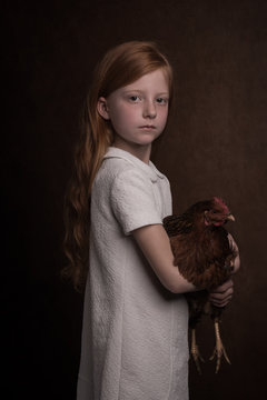 Studio portrait of girl holding hen