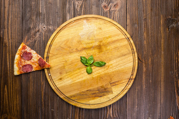 Pizza pepperoni with mozzarella cheese, salami and arugula on wooden background