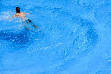 Man swimming in pool in summer
