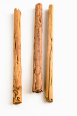 Stack of cinnamon sticks on white background and space
