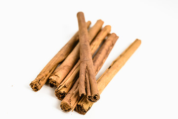 Stack of cinnamon sticks on white background and space