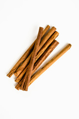 Stack of cinnamon sticks on white background and space