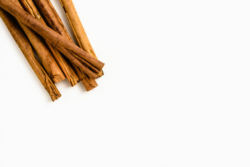 Stack of cinnamon sticks on white background and space