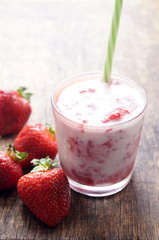 Fresh strawberry cocktail milkshake on a wooden background. Healthy food for breakfast and snacks.
