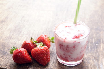 Fresh strawberry cocktail milkshake on a wooden background. Healthy food for breakfast and snacks.