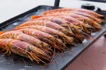 King shrimps with olive oil cooking on electric black grill. Seafood preparation concept