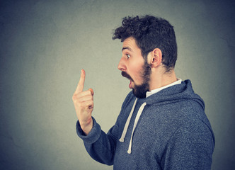 Amazed man looking at finger in shock