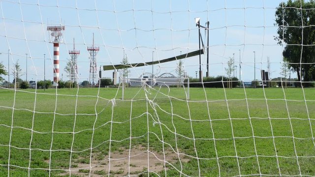 Porte di calcio e sullo sfondo l'aeroporto di Milano Linate