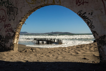 Arc of ruined fortress in La Serena with views of Coquimbo city on the background, Chile. Abandoned building by the beach