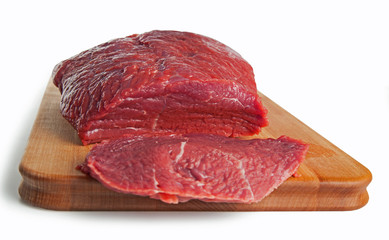 Raw beef meat piece and slice on a board, isolated on white background. Selective focus.