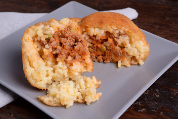 Arancina with meat on gray plate 