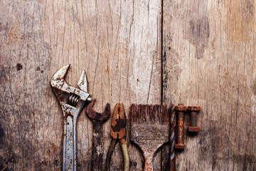Old rusty tools on old wood background. vintage photo