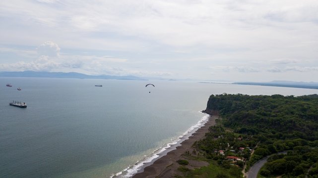 Beautiful aerial view of the beach with parapenting in the horizon