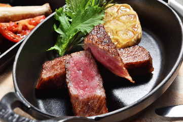  Grilled beef steaks with garlic on grill iron pan 