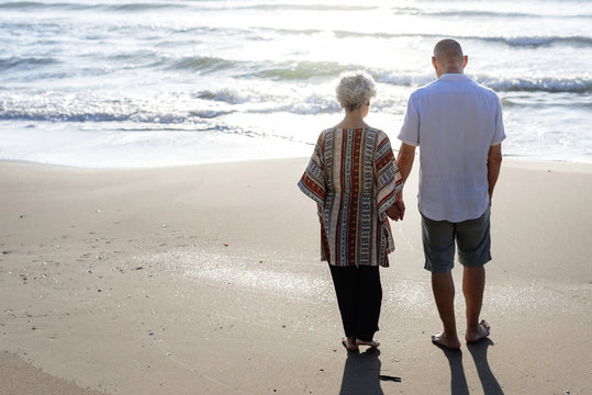 Mature Couple Walking Together At The Beach