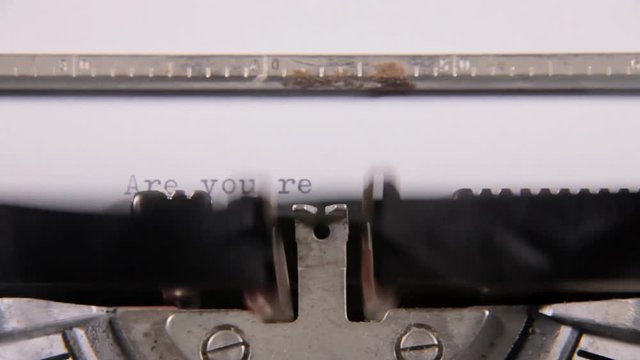 Typing the words Are you ready? on a blank paper sheet with an old vintage typewriter. With diegetic audio.

