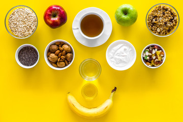 Obraz na płótnie Canvas Ideas of healthy hearty breakfast for sportsmen. Fruits, oatmeal, yogurt, nuts, crispbreads, chia on yellow background top view copy space