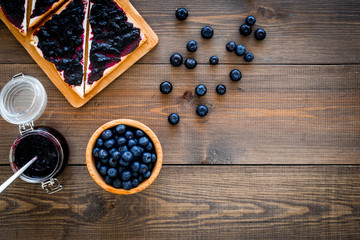 Sandwiches with blueberry jam for breakfast on dark wooden background top view copy space