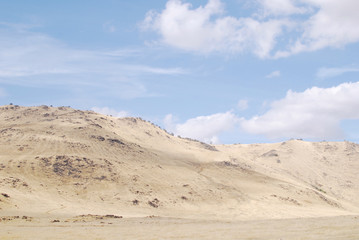 Fototapeta na wymiar Landscape with dry land and blue cloudy sky