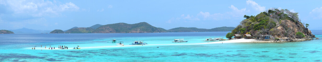 Sandbar with tourists and boats on the tropical Bulog Uno island, Palawan, Philippines
