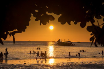 Silhouette of a people walking at amazing orange sunset over the sea at Boracay island Philippines