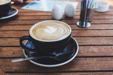 close up image of a hot cup of coffee in a black cup