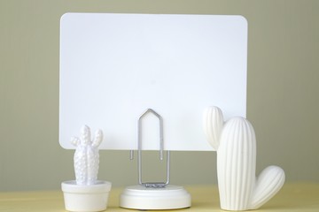 Empty board Mockup with white ceramic cactus set on a yellow background.Minimalist Mockup. copy space.