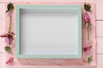 empty vintage frame. pastel green frame with dry buds of roses on a pastel pink background.empty interior frame.  frame mockup.