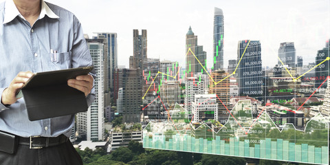 Businessman  standing and operate tablet to control and connect big data of real estate sector...